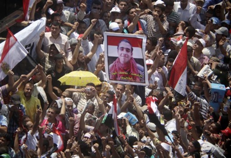 Egyptians shout anti-Mubarak slogans as they carry a poster showing Yousef Anwar, one of hundreds who were killed, at Tahrir Square, the focal point of the Egyptian uprising, in Cairo, Egypt, Friday, July 8, 2011. Thousands of Egyptians took to the streets around the country Friday to demand justice for victims of Hosni Mubarak's regime and press the new military rulers for a clear plan of transition to democracy. (AP Photo/Amr Nabil)
